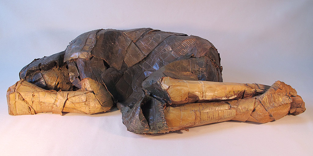 'A plaster-soaked cloth wrap body lying on the floor in a semi-fetal position'